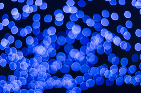 Many blue bokeh lights on dark backgroundの写真素材