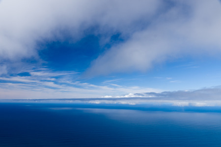 Cloudy sky and calm ocean background, high angle viewの写真素材