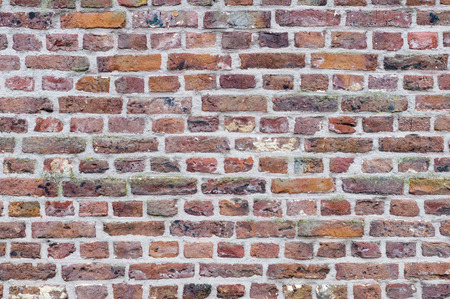 Old brick wall background, different size and color bricksの写真素材