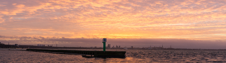 Panoramic view of Tallinn city silhouette and sea pier on sunsetの写真素材