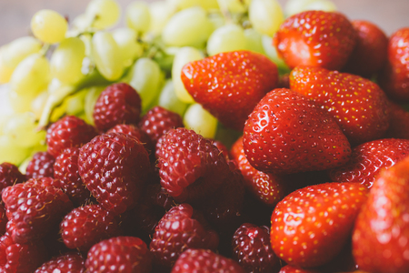 Closeup on strawberries, raspberries and grapes, selective focus