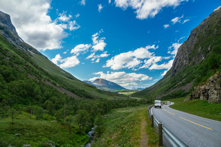 Campers and cars on scenic road between mountains. Wonderful summertime landscape. Recreational tourism conceptの写真素材
