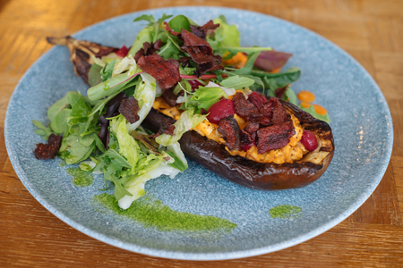 Baked eggplant with fresh lettuce, carrot cream and vegetable crisps. Vegan cuisineの写真素材