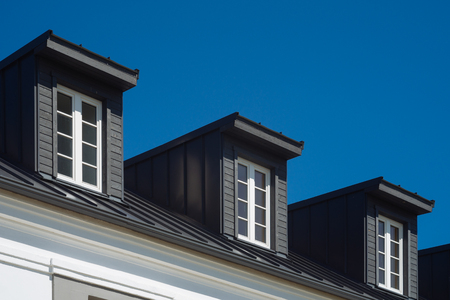 View on top of residential house facade against blue sky, real estate concept
