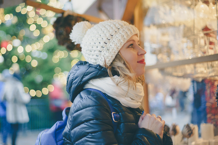 Young female looking at holiday presents on Christmas marketの写真素材