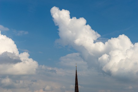 Spire with cross against cloudscape, faith and religion conceptの写真素材