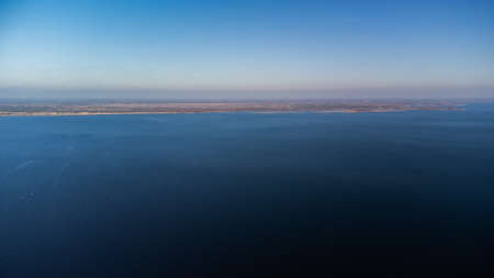 Beautiful autumn nature landscape. Flying above river, swamps, mixed forest, yellow regular trees. Aerial shot, 4Kの写真素材