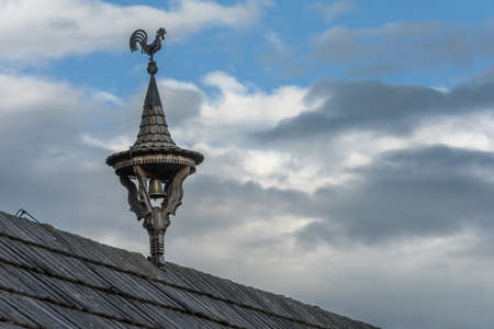 weathercock with a bell on a small wooden towerの写真素材