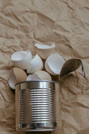 Eggshell in tin top view. Creative still life photo of an Eggshell in a tin can on brown background.の写真素材
