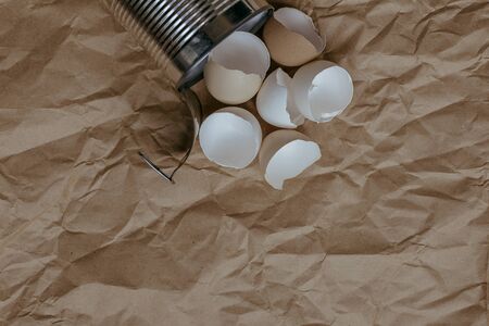 Eggshell in tin top view. Creative still life photo of an Eggshell in a tin can on brown background.の写真素材
