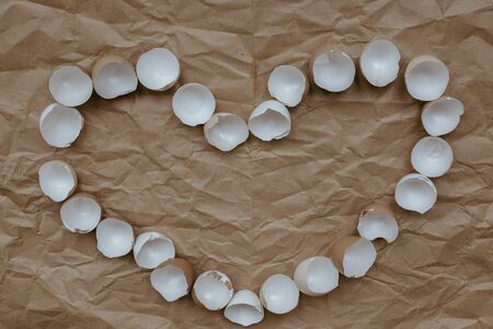The eggshell is folded in the shape of a heart on Kraft paper.の写真素材
