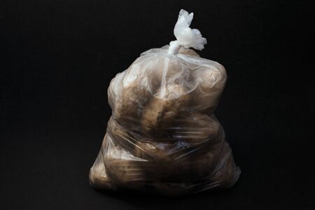 Transparent bag with potatoes on a dark background. Potato packaging.の写真素材