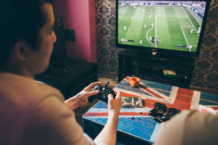 CHELYABINSK, RUSSIA, FEBRUARY 23, 2017: A young people holding and playing a game controller for the Microsoft Xbox, a video game console.のeditorial素材