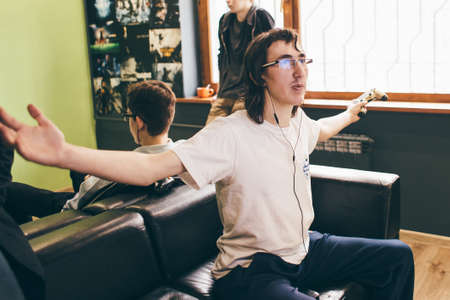 CHELYABINSK, RUSSIA, FEBRUARY 23, 2017: A young people holding and playing Sony Dualshock controller for the PlayStation, a video game console.のeditorial素材