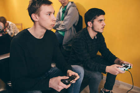 CHELYABINSK, RUSSIA, FEBRUARY 23, 2017: A young people holding and playing Sony Dualshock controller for the PlayStation, a video game console.のeditorial素材