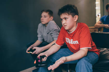CHELYABINSK, RUSSIA, FEBRUARY 23, 2017: A young people holding and playing Sony Dualshock controller for the PlayStation, a video game console.のeditorial素材