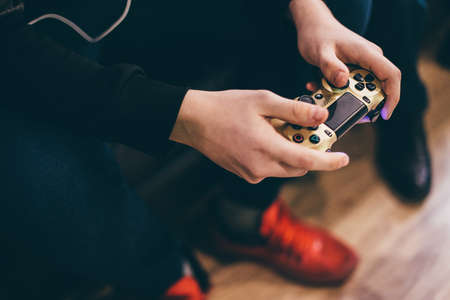 Hand man playing Sony Dualshock controller for PlayStation.のeditorial素材