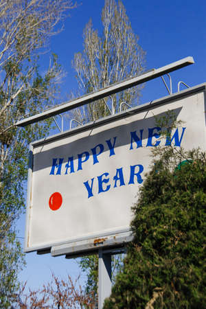 Happy New Year on the billboard between the Christmas treesの写真素材