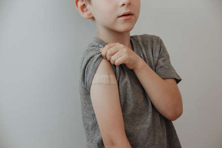 Vaccinated Boy Showing Arm After Covid-19 Vaccine Injectionの写真素材