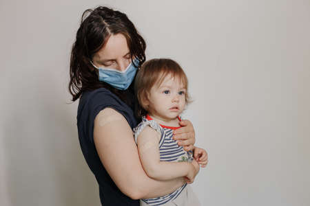 mother and daughter, a child after vaccination. The woman makes a stop gesture. Stop viruses conceptの写真素材