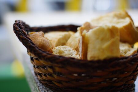 Closeup of fresh white bread for breakfast in brown wicker basket. Macro picture, bread texture
