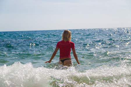 Sexy girl in sportswear and tanga string gets into the seaの写真素材