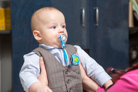 Very serious newborn boy in a suit