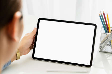 Closeup of woman hand holding digital tablet on the table and the screen is blank.の写真素材