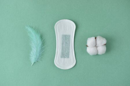 The daily pad in the center with the right cotton with the left of it the pen on the green...