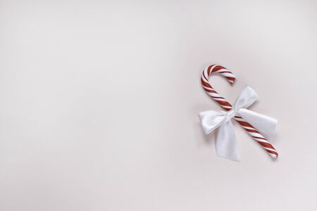One bright pink candy with a white bow in the form of a cane.