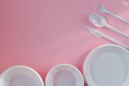 Plastic white dishes on a pink background on the right and bottomの写真素材