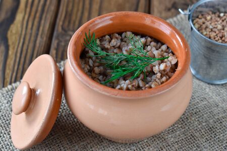 One small pot of boiled buckwheat next to the lid. Healthy breakfast. Light dinner.の写真素材