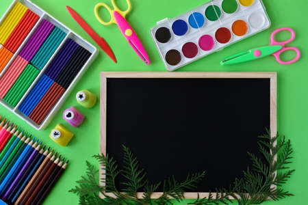Back to school. A geometrically constructed stationery with thuja twigs has room for text.