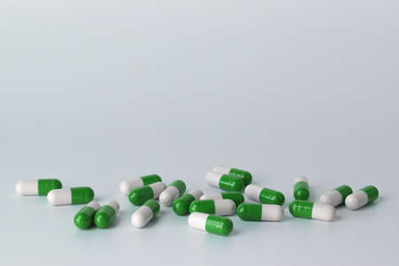 Capsules are scattered in a chaotic order on a white backgroundの写真素材