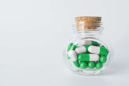 Glass container with capsules on a white background with a copy spaceの写真素材