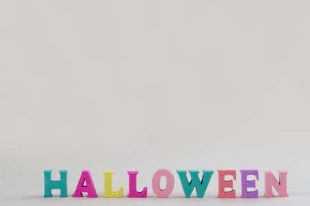 Wooden colored letters with the inscription Halloween on a pastel background with a space for text