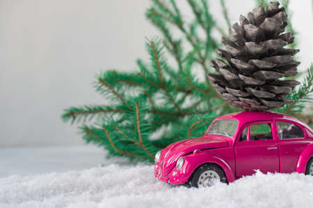 Kirov, Russia - October 9, 2020, Pink toy car with a fir cone on the roof in the snowの写真素材