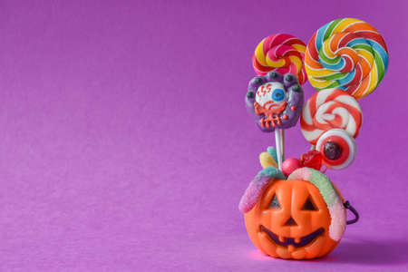 Basket in the form of a pumpkin with various candies. Holiday chores