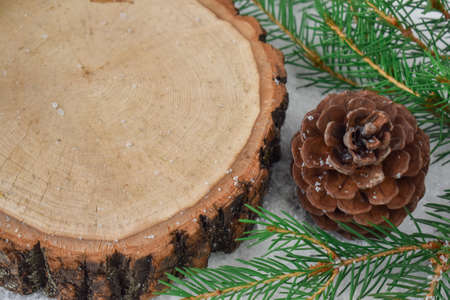 Close-up of a wooden section with a copy of the space next to spruce branches in the snow