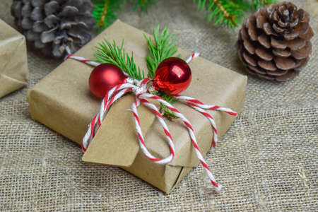 Christmas tree branches with gift box on fabric background