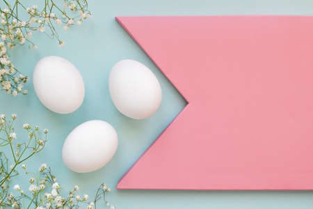 Three white chicken eggs with flowers with a copy of the space.の写真素材