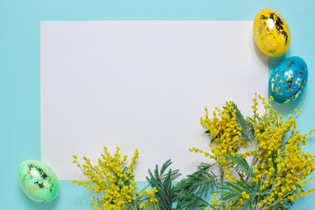 A blank sheet of paper copies the space with the sprigs of mimosa Easter eggs. Brand minimalism. A postcard for Easter.の写真素材