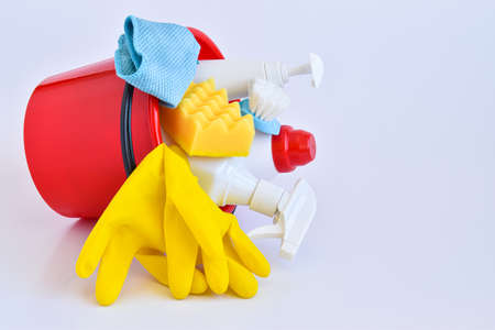 Cleaning products in a red bucket on a white one. Bottles of detergent. The concept of cleaning in the house, apartment, office. Household chemicals.の写真素材