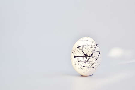 One white speckled egg on a white background. Easter. Minimalism, copy space, blank space for text....