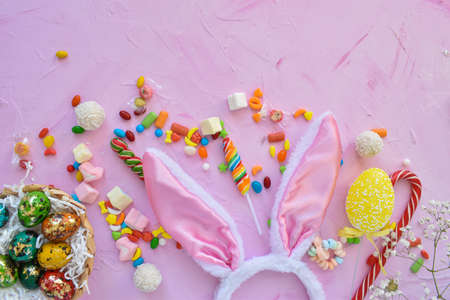 Easter composition with sweets, rabbit ears and tulips. Happy