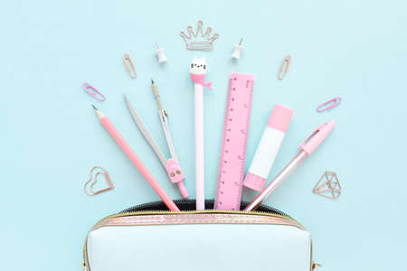Light blue pencil case with pink stationery on a light pastel background. Flat lay