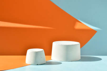 The podium is an orange-blue background with a geometric figure made of concrete. A scene with a...