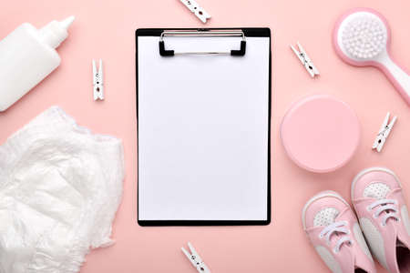An empty notebook on a pink background with children's accessories for body care. Flat lay, top view, copy space.の写真素材