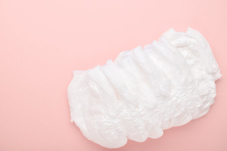 Diapers are disposable panties on a pink background with a place to copy. top view, copy space.の写真素材