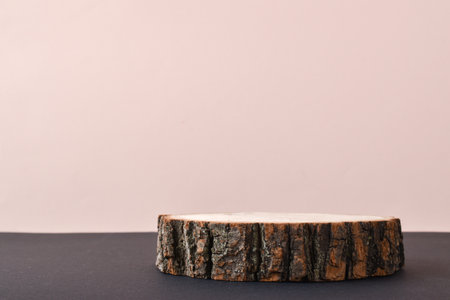 A wooden stage with a green branch with shadows for a presentation on a beige background. The podium is made of natural material with space for text. Minimalistic branding scene.の写真素材